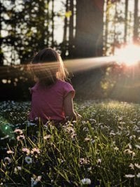 meisje in het gras aan daglicht blootgesteld